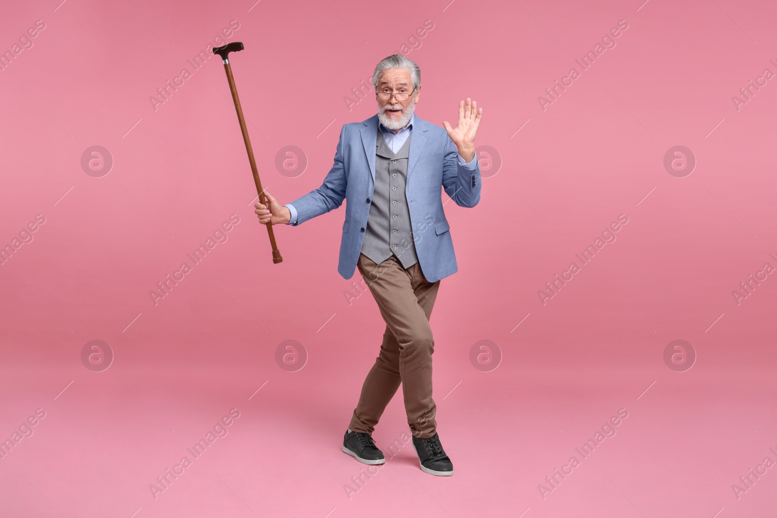 Photo of Senior man with walking cane on pink background