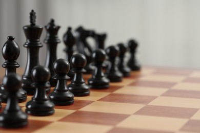 Photo of Chess board with black wooden pieces, closeup. Space for text