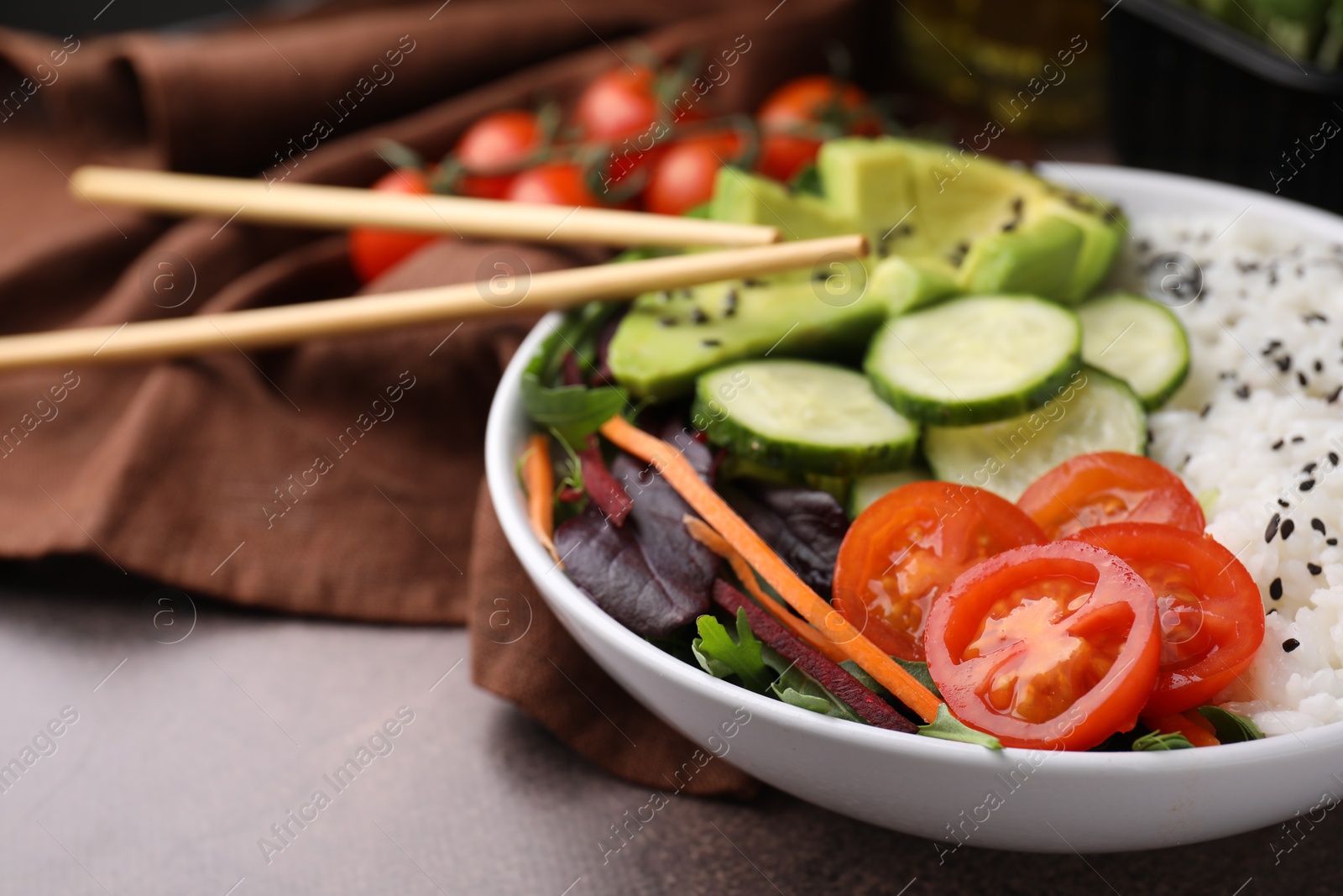 Photo of Delicious poke bowl with vegetables, avocado and mesclun on textured table, closeup