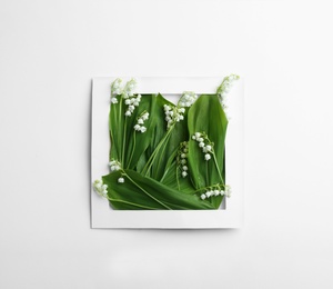 Photo of Paper frame with lily of the valley flowers on white background, top view