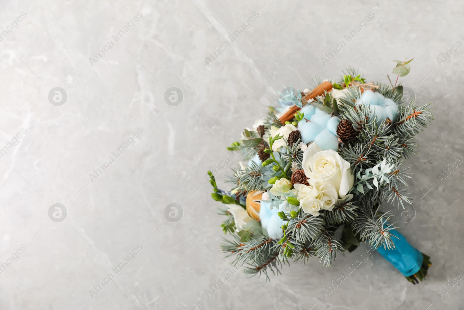 Photo of Beautiful wedding winter bouquet on grey table, top view. Space for text