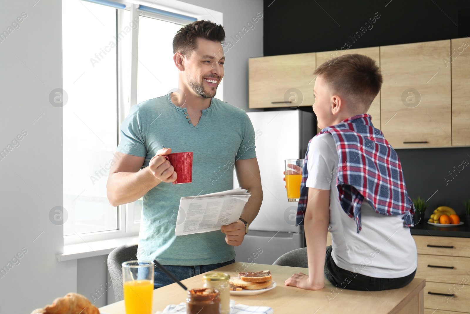 Photo of Dad and son having breakfast together in kitchen