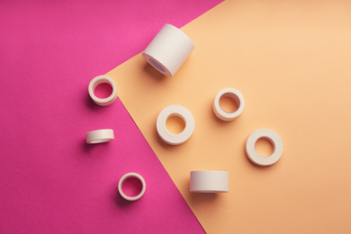 Sticking plaster rolls on color background, flat lay