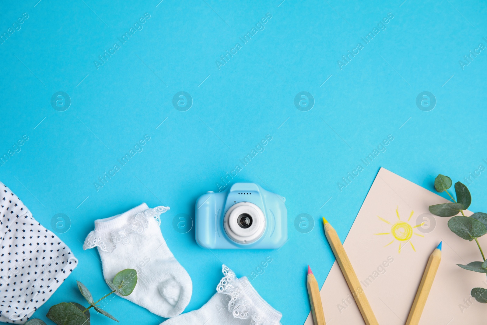 Photo of Flat lay composition with toy camera on light blue background, space for text. Future photographer