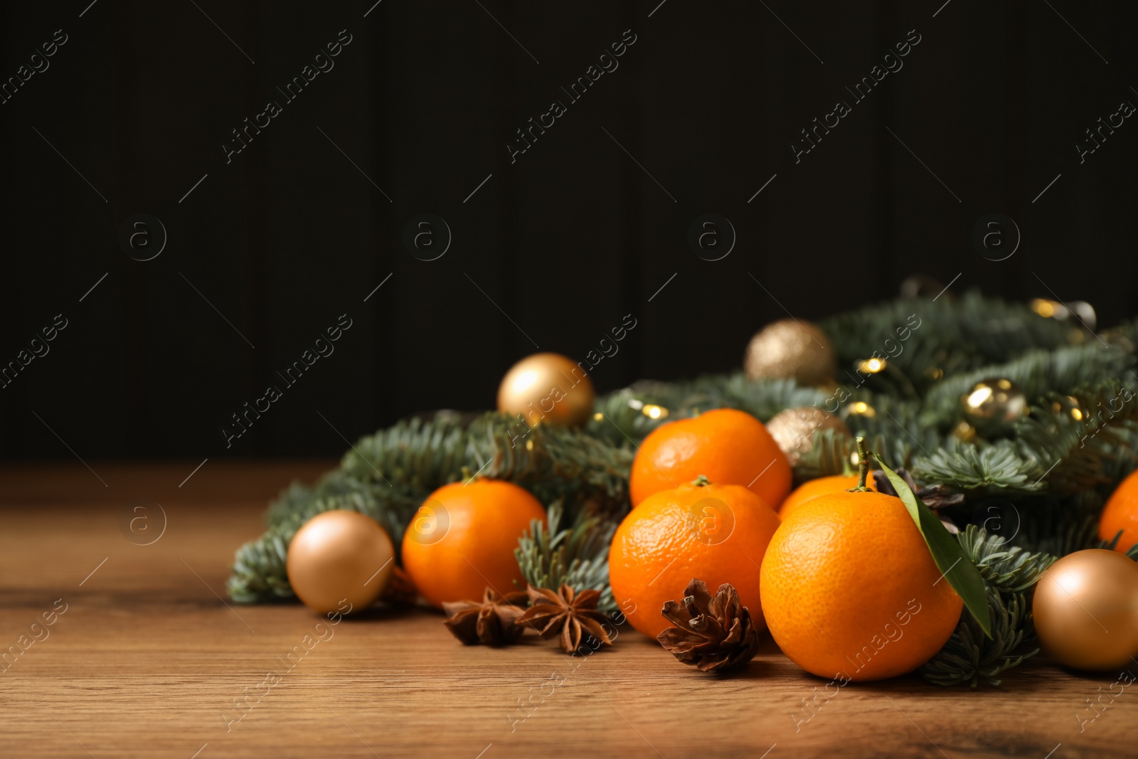 Photo of Christmas composition with tangerines on wooden table. Space for text