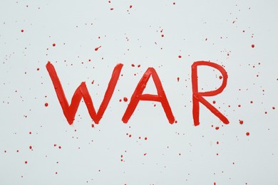 Photo of Word War written with red paint on white background, top view