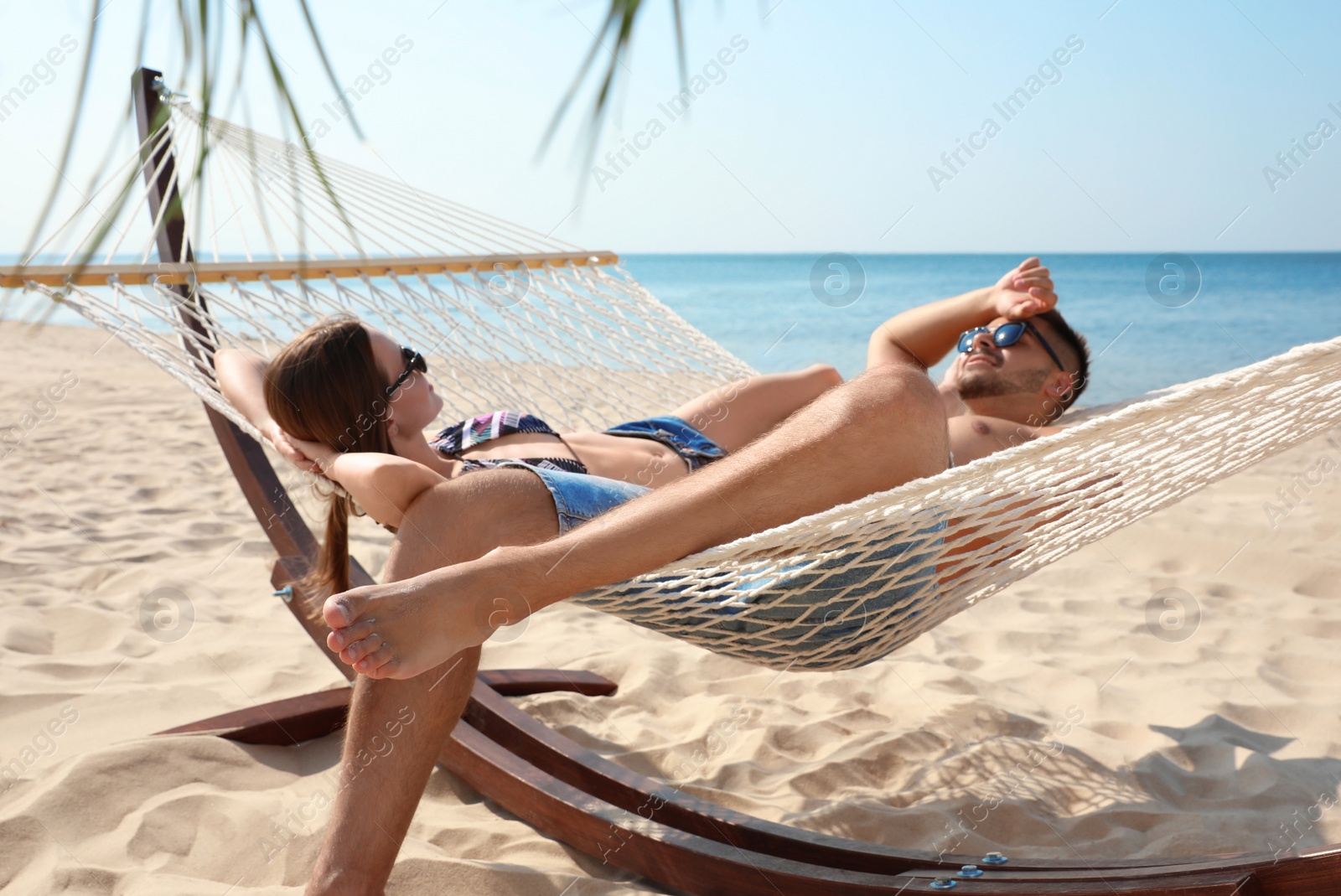 Photo of Young lovely relaxing in hammock on beach