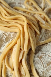 Raw homemade pasta and flour on table, closeup