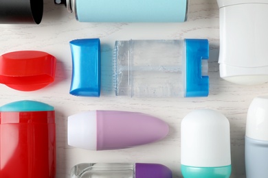 Photo of Flat lay composition with different deodorants on white wooden table