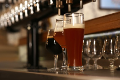 Different beers in glasses on bar counter