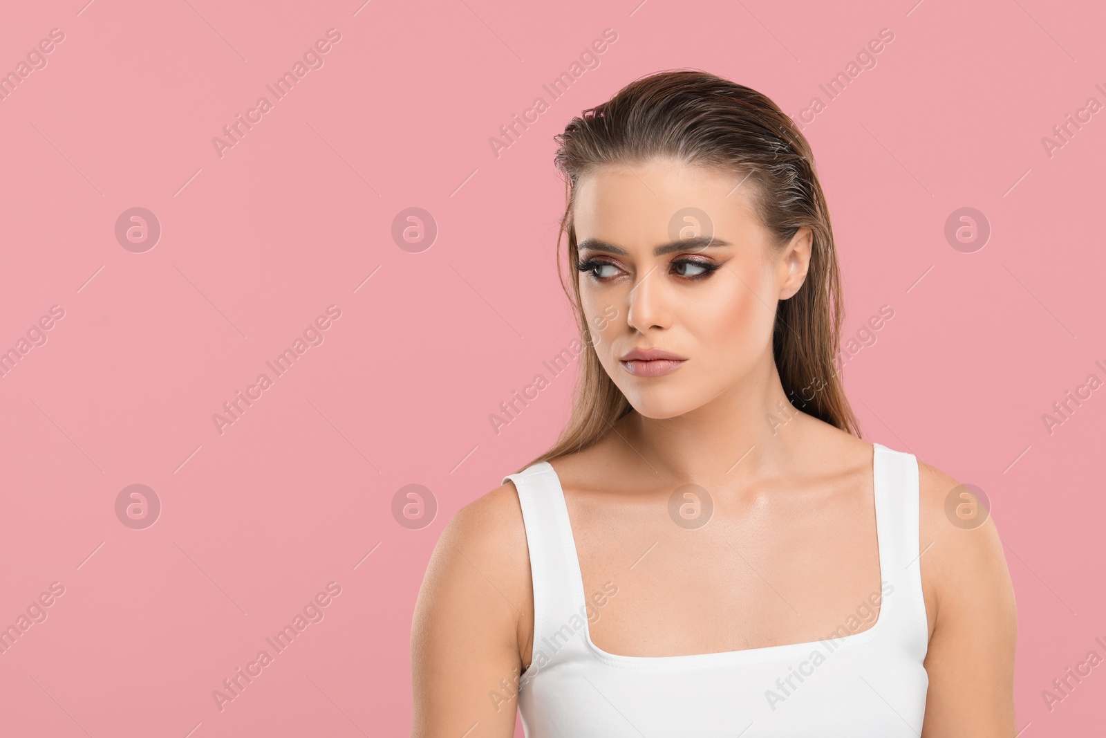 Photo of Beautiful woman with makeup on pink background, space for text