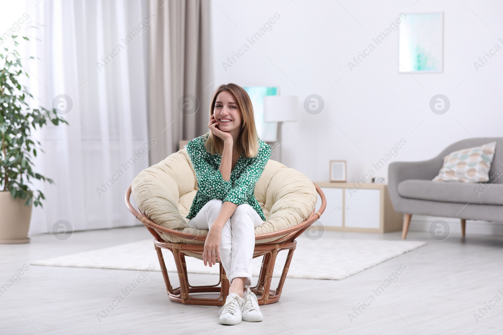 Photo of Attractive young woman sitting in armchair at home