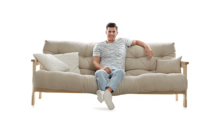 Man relaxing on comfortable sofa against white background