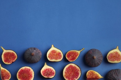 Delicious ripe figs on blue background, flat lay. Space for text