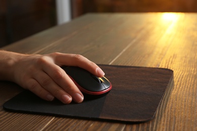 Photo of Woman using computer mouse at table, closeup. Space for text