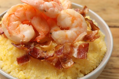 Fresh tasty shrimps, bacon and grits in bowl on table, closeup