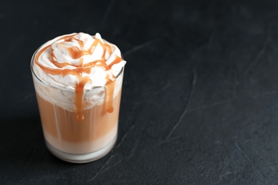 Glass with delicious caramel frappe on grey background