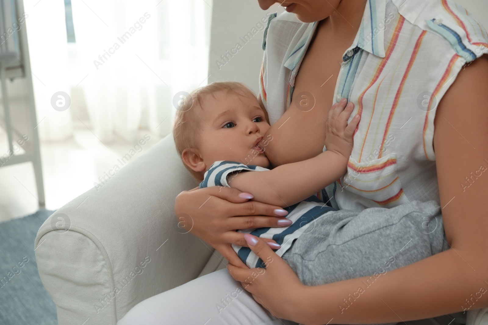 Photo of Woman breastfeeding her little baby at home