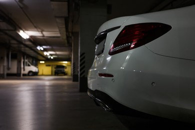 Photo of White car in parking garage, closeup. Space for text
