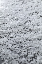 Scattered natural salt on black table, closeup