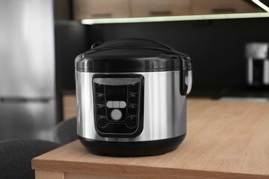 Photo of Modern multi cooker on table in kitchen