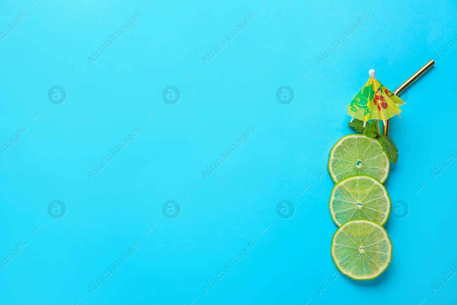 Photo of Creative image of summer cocktail made with lime slices, mint and straw on color background, top view. Space for text