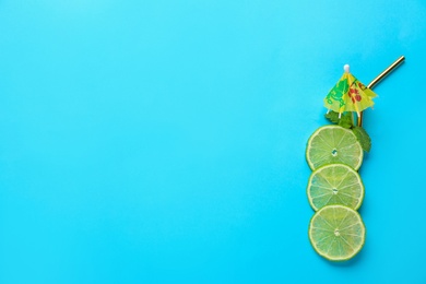 Photo of Creative image of summer cocktail made with lime slices, mint and straw on color background, top view. Space for text