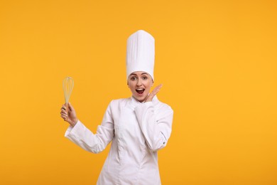 Photo of Surprised professional confectioner in uniform holding whisk on yellow background