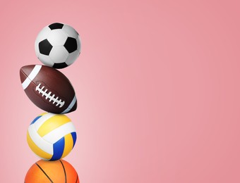 Stack of different sport balls on pink background, space for text