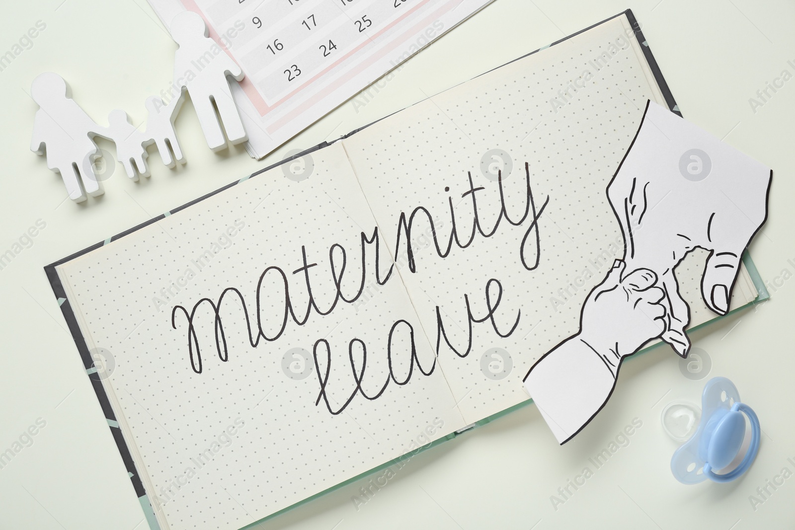 Photo of Flat lay composition with notebook and paper cutout of hands on beige background. Maternity leave concept