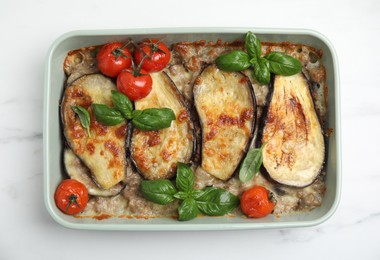 Photo of Delicious eggplant lasagna in baking dish on white marble table, top view