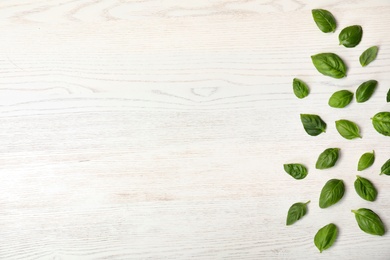 Fresh green basil leaves and space for text on wooden background, top view