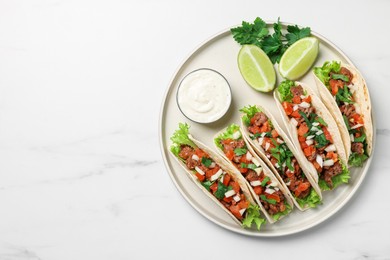 Delicious tacos with meat and vegetables served on white marble table, top view. Space for text