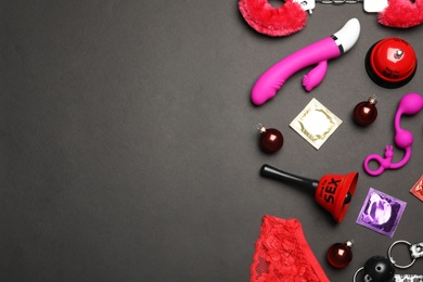 Different sex toys on black background, flat lay. Space for text