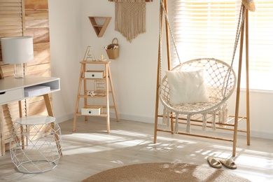 Photo of Comfortable hammock chair in stylish room. Home interior