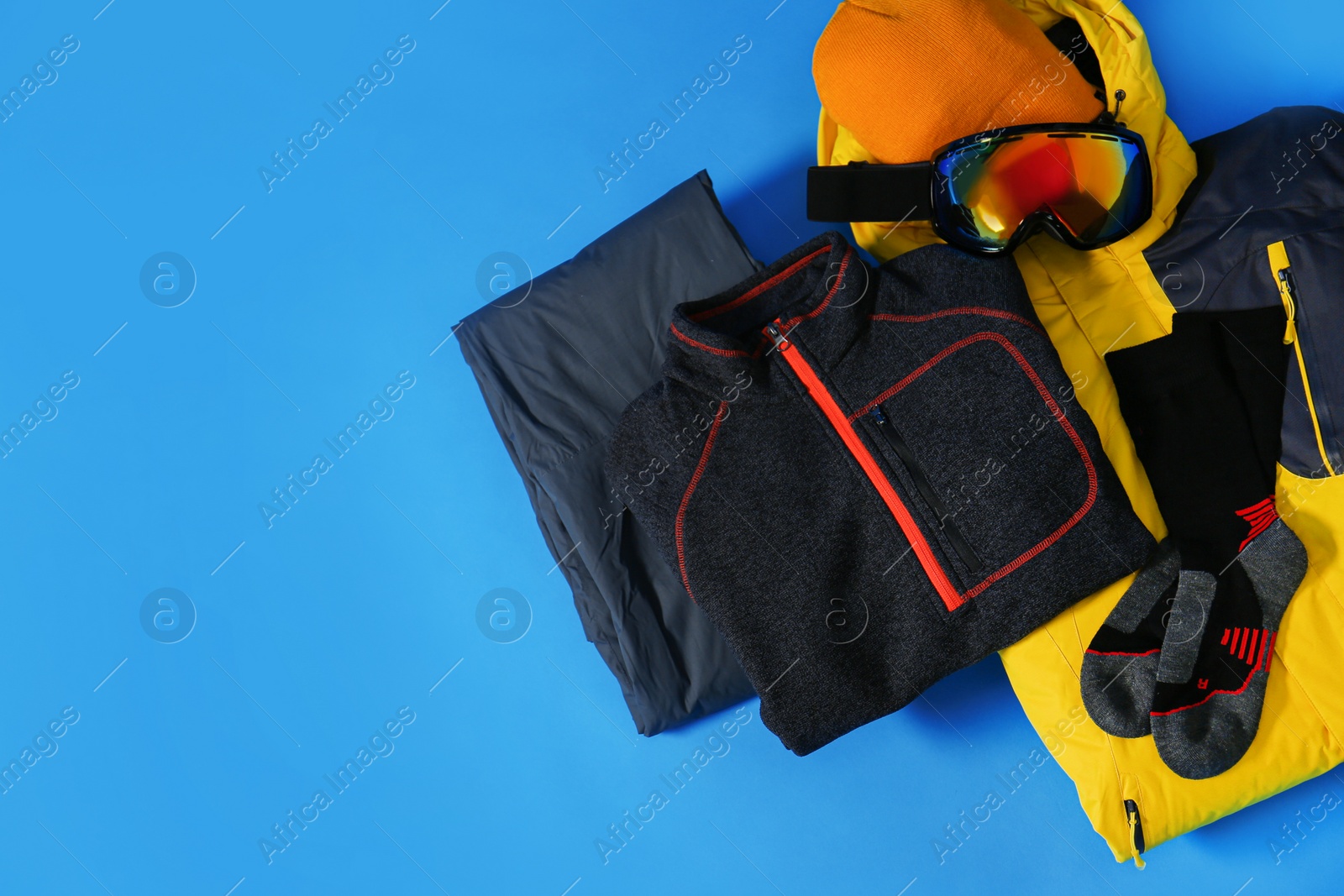 Photo of Stylish winter sport clothes on light blue background, flat lay