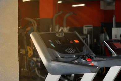 Photo of Black treadmill in gym. Modern sport equipment