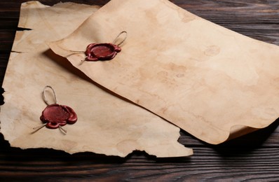 Sheets of old parchment paper with wax stamps on wooden table