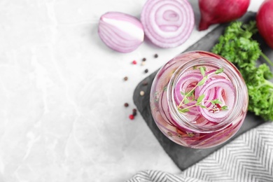 Photo of Flat lay composition with jar of pickled onions on marble table. Space for text