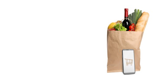 Image of Online purchases. Smartphone with shopping cart icon and paper bag full of different products on white background