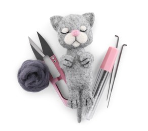 Photo of Needle felted cat, wool and tools isolated on white, top view