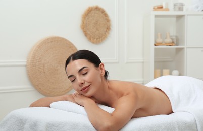 Photo of Beautiful young woman relaxing in spa salon