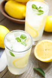 Photo of Glasses of cold lemonade on wooden table, above view