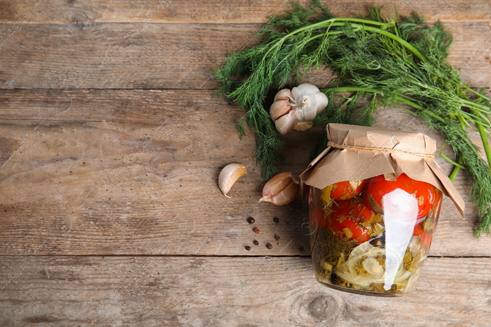 Photo of Flat lay composition with pickled tomatoes in glass jar on wooden table, space for text