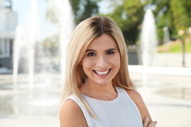 Portrait of beautiful blonde woman outdoors on sunny day