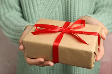 Photo of Woman holding beautiful Christmas gift with bow, closeup