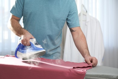 Man ironing clean shirt at home, closeup