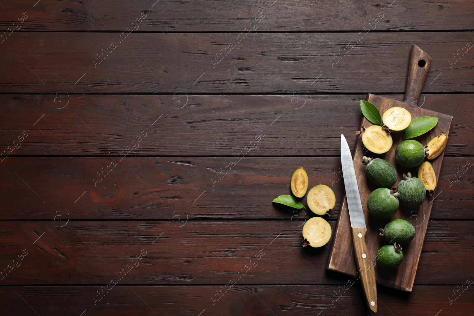 Photo of Flat lay composition with fresh green feijoa fruits on wooden table, space for text