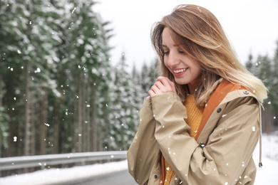 Photo of Young woman in warm clothes outdoors on snowy day, space for text. Winter vacation