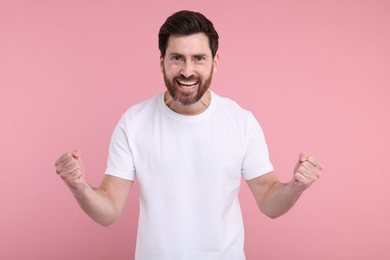 Photo of Portrait of happy surprised man on pink background